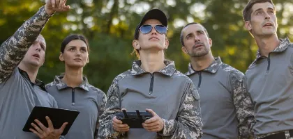 Foto de personal del gobierno mirando al cielo mientras prueba un dron